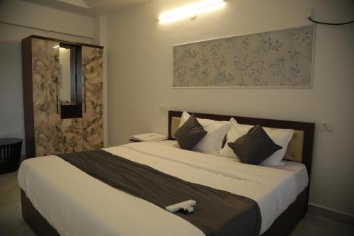 a bedroom with a large bed with a wooden headboard at Rivayn Suites in Thiruvalla