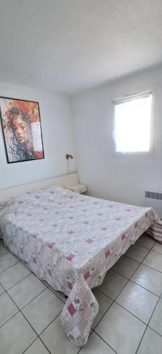 a bedroom with a bed with a quilt on it at 3 pièces proche plage commerces et golf in Pornic