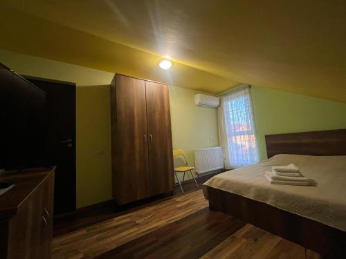 a bedroom with a bed and a wooden cabinet at Casa Daria Oradea in Oradea