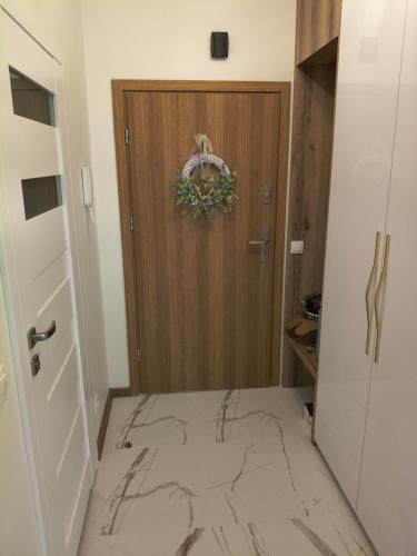 a bathroom with a wooden door and a marble floor at Apartament przy Matce Polce in Łódź