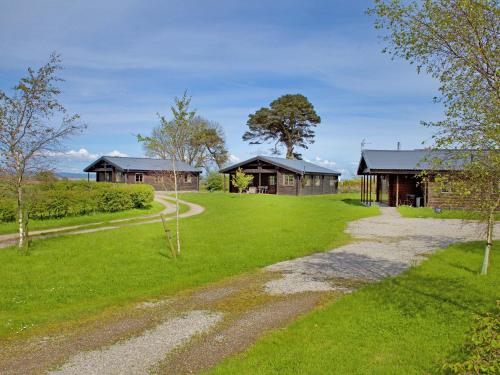 a path leading to two houses in a field at Lapwing Lodge - Uk51640 in Carsethorn