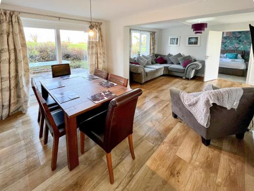 a living room with a wooden table and chairs at Primrose Apartment - Uk49291 in Woolfardisworthy