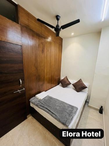 a bedroom with a bed and a wooden door at Elora Hotel in Ujjain