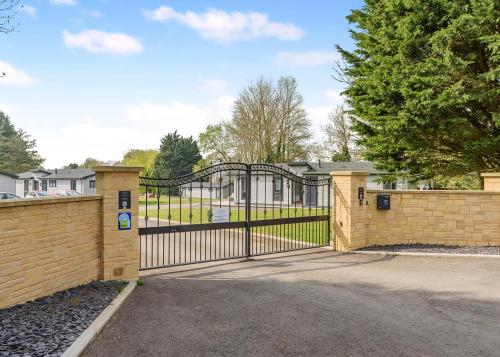 a gate in a brick fence with a driveway at Faringdon Grange in Faringdon