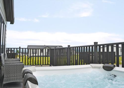 a hot tub on a patio with a fence at Lillyhall Lodge Retreat in Workington