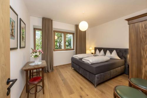 a bedroom with a bed and a table and chairs at Suite Lazzeri in Cortaccia