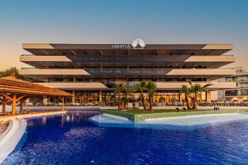 a hotel with a swimming pool in front of a building at Liberty S Hotel in Novalja