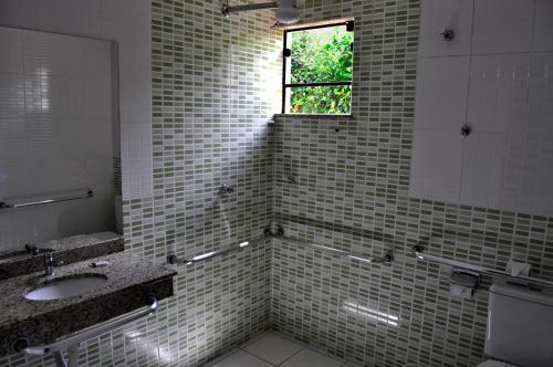 a bathroom with a sink and a window at Hotel Maranhão in Ourinhos