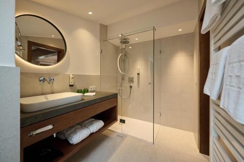 a bathroom with a sink and a shower at Haldenhof in Lech am Arlberg