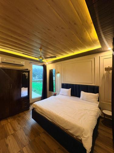 a bedroom with a large bed with a wooden ceiling at Lagoon Bites in Jhājra
