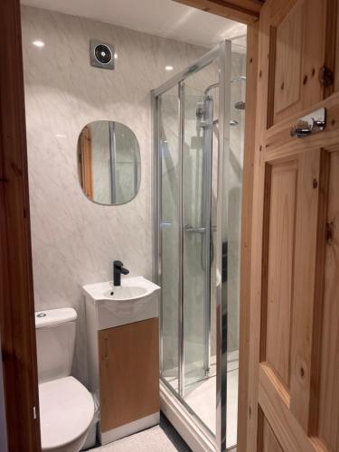 a bathroom with a shower and a toilet and a sink at Home from Home 1 in Castleford