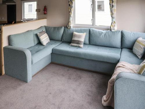 a blue couch in a living room with pillows at Birch 3 - Ukc8216 in Pendine