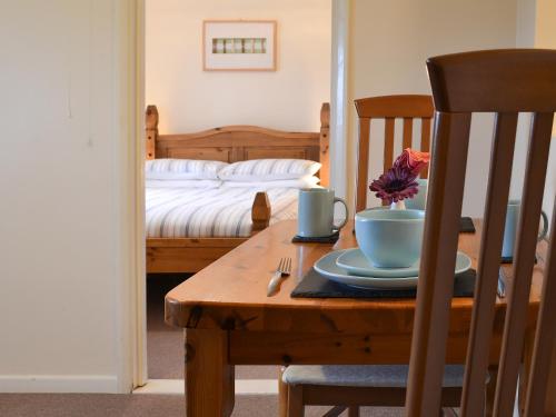 a table with a plate on it with a bed at Bramling Apartment - Uk49302 in Woolfardisworthy