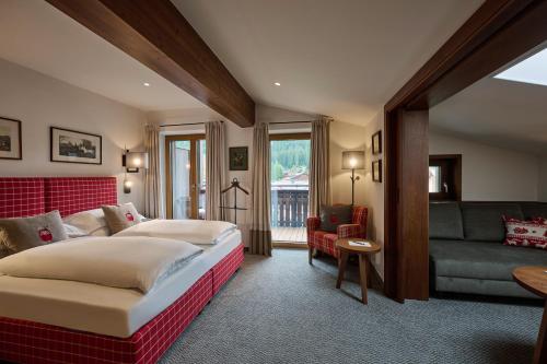 a hotel room with a bed and a couch at Haldenhof in Lech am Arlberg