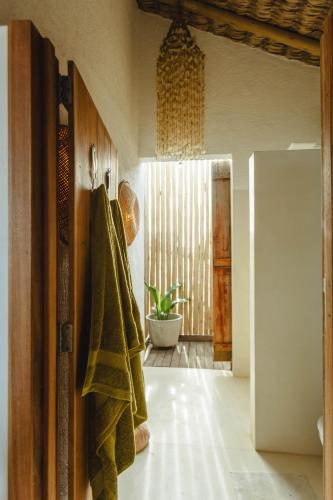 a bathroom with a towel hanging on the wall at Yvytu - Ohana Bungalow in Tatajuba