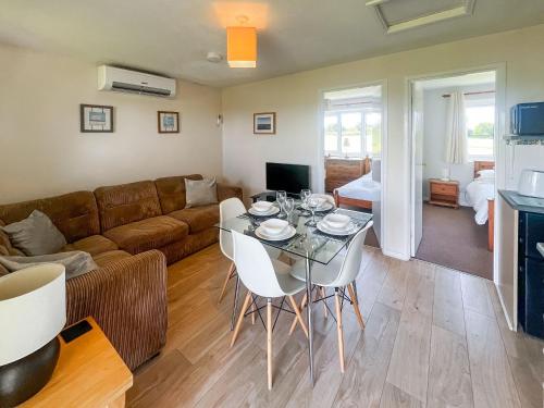 a living room with a couch and a table and chairs at Holly Apartment - Uk49299 in Woolfardisworthy