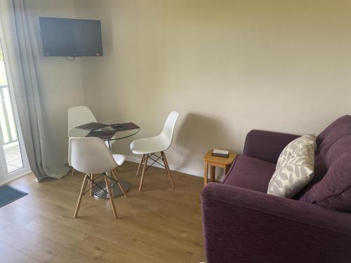 a living room with a couch and a table and chairs at Chestnut Apartment - Uk49277 in Woolfardisworthy