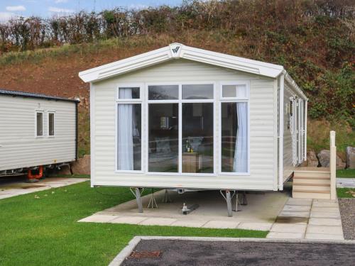 a small white shed with a large window at Birch 1 - Ukc8214 in Pendine