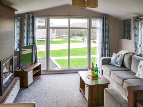 a living room with a couch and a tv at Birch 1 - Ukc8214 in Pendine