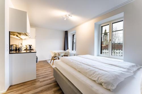 a white bedroom with a large bed and a window at TouchBed in St. Gallen