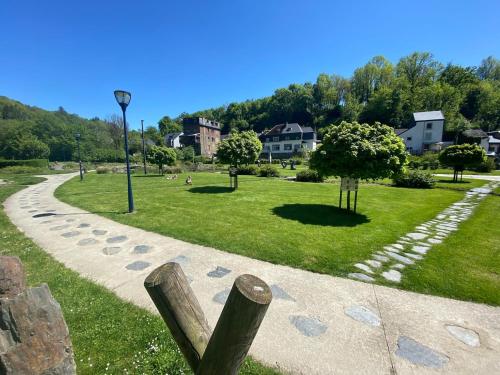 a park with a path and trees and buildings at Les Variétés in La-Roche-en-Ardenne