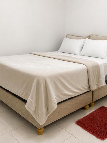 a bed with white sheets and pillows on it at Apto Albor Blanco in Popayan