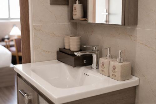 a bathroom sink with two soap dispensers on it at Olivia Hotel in Ấp Thành