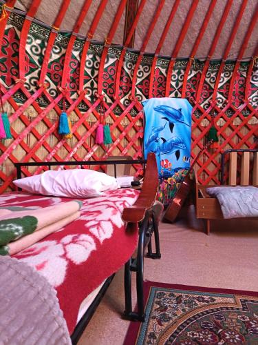 a room with two beds and a chair in a yurt at Uort in Tossor