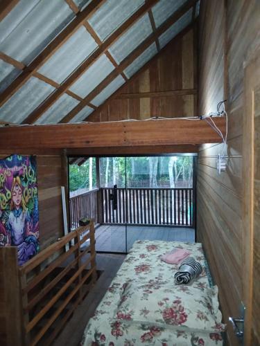 ein Schlafzimmer mit einem Bett in einer Holzhütte in der Unterkunft Altér Chale in Santarém