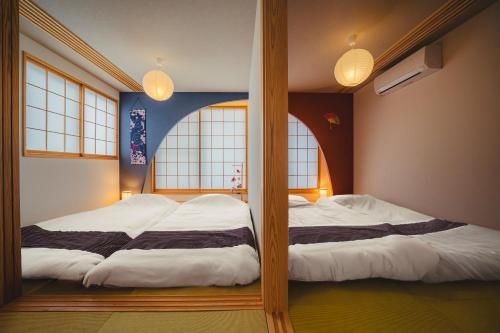 two bunk beds in a room with two windows at ヒカリとテラス in Nagano
