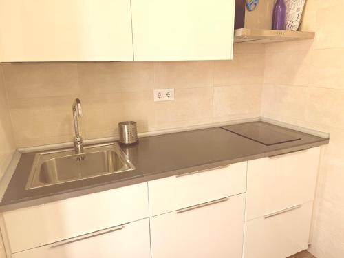 a kitchen with a sink and white cabinets at San Millán 1 in Soria