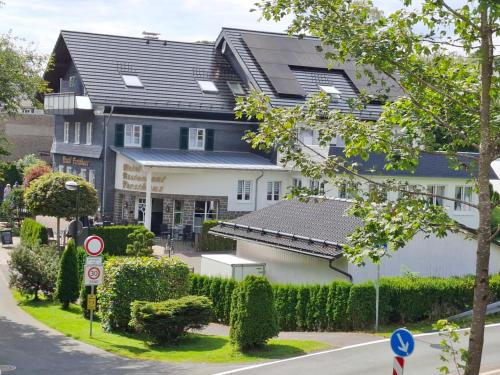 a large white building with a black roof at Hotel Forsthaus in Winterberg