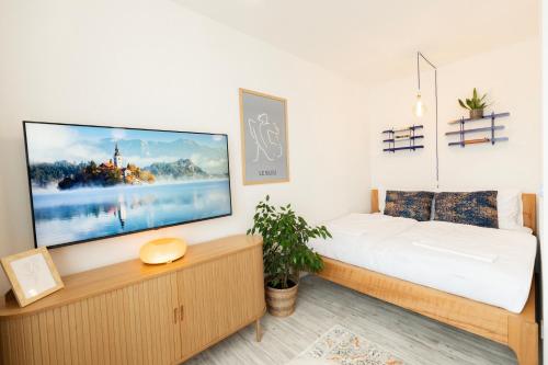 a bedroom with a large flat screen tv on the wall at Atelier Lion in Žďár nad Sázavou
