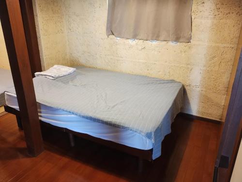 a small bed in a corner of a room at Unwind DAY OFF Nagamo in Yaese