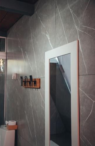 a bathroom with a mirror and a wall at Cabana dos sonhos Chalé experience Hidro CinemaSPA in Mateus Leme