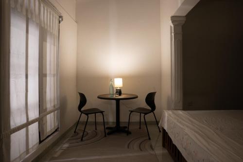 a room with a table with two chairs and a lamp at Aviyan Villa Wadduwa in Wadduwa