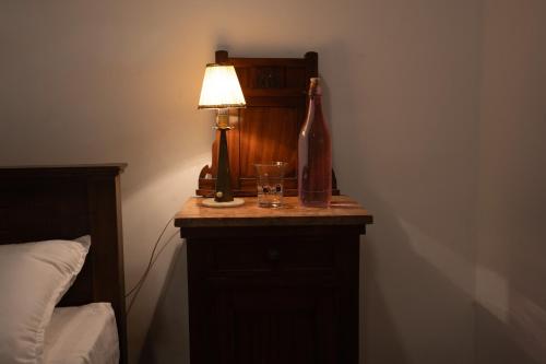 a table with a lamp and a bottle and a glass at Aviyan Villa Wadduwa in Wadduwa