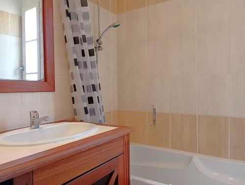a bathroom with a sink and a shower and a tub at Villa l Albatros - Coex in Coëx