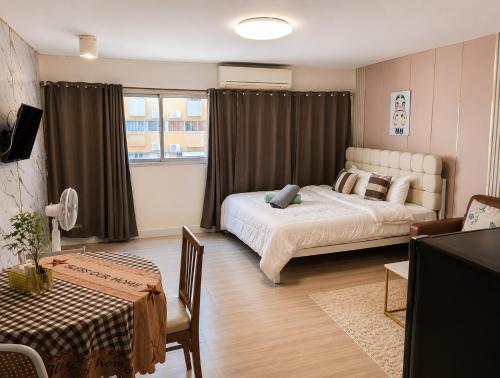 a bedroom with two beds and a window with curtains at IMPACT popular condo c5 แม่ตังค์ in Ban Bang Phang