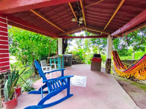 a patio with blue chairs and a table and hammocks at Las Catalinas Ecológicas (El Maizal) in Antón