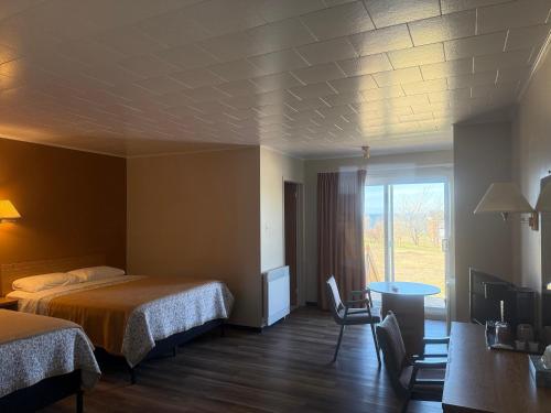 a hotel room with two beds and a window at Le Campagnard in Matane
