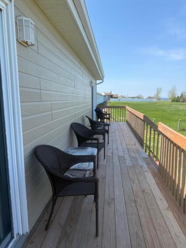 a row of chairs sitting on the porch of a house at Le Campagnard in Matane