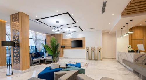 an office lobby with blue furniture and a tv at Al Qasr Hotel Al Rabwah in Abha