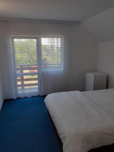 a bedroom with a bed and a large window at Casă Bubu in Cacica