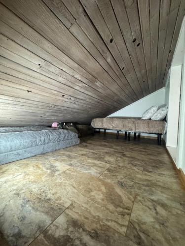 two beds in a room with a wooden ceiling at Canvasback Cove on Caddo Lake in Jefferson