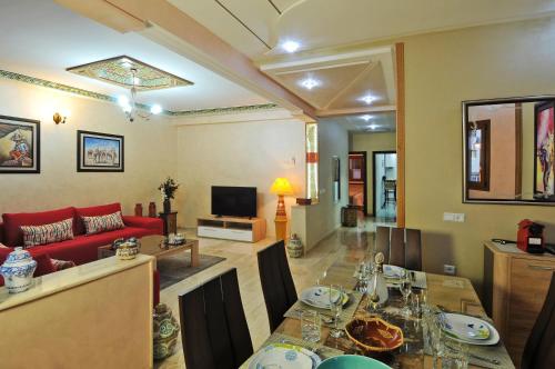 a living room with a table and a red couch at Aparthotel Les Oliviers Suites & Spa in Fès