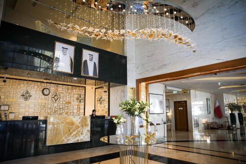 eine Lobby mit einem Glastisch und einem Kronleuchter in der Unterkunft Century Hotel Doha in Doha