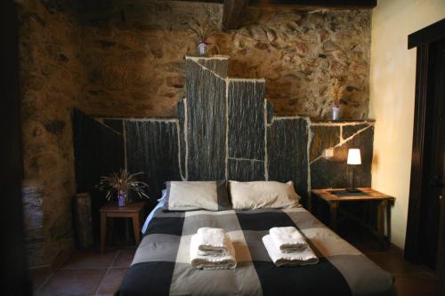 a bedroom with a bed with two towels on it at Hotel Rural Bermellar in Bermellar