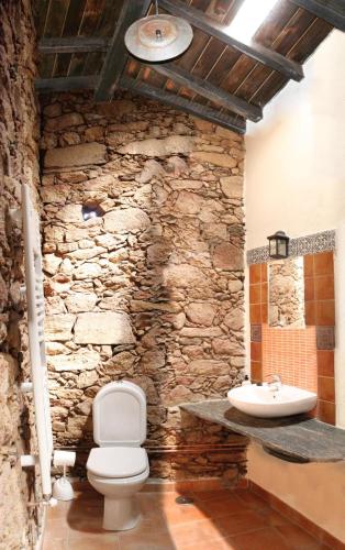 a stone bathroom with a toilet and a sink at Hotel Rural Bermellar in Bermellar