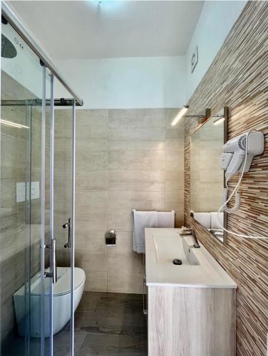 a bathroom with a sink and a toilet and a shower at LaDependance Hotel Scilla in Scilla